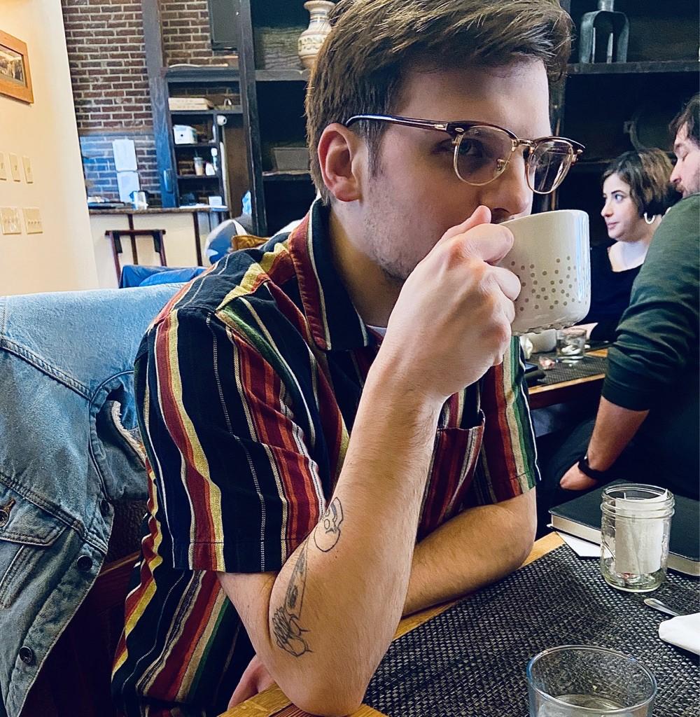 Male drinking coffee at table, The Palisades