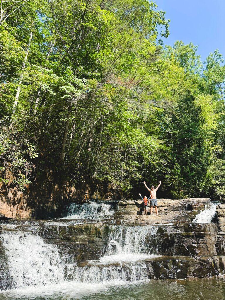 man and boy standing on top of waterfall outside
