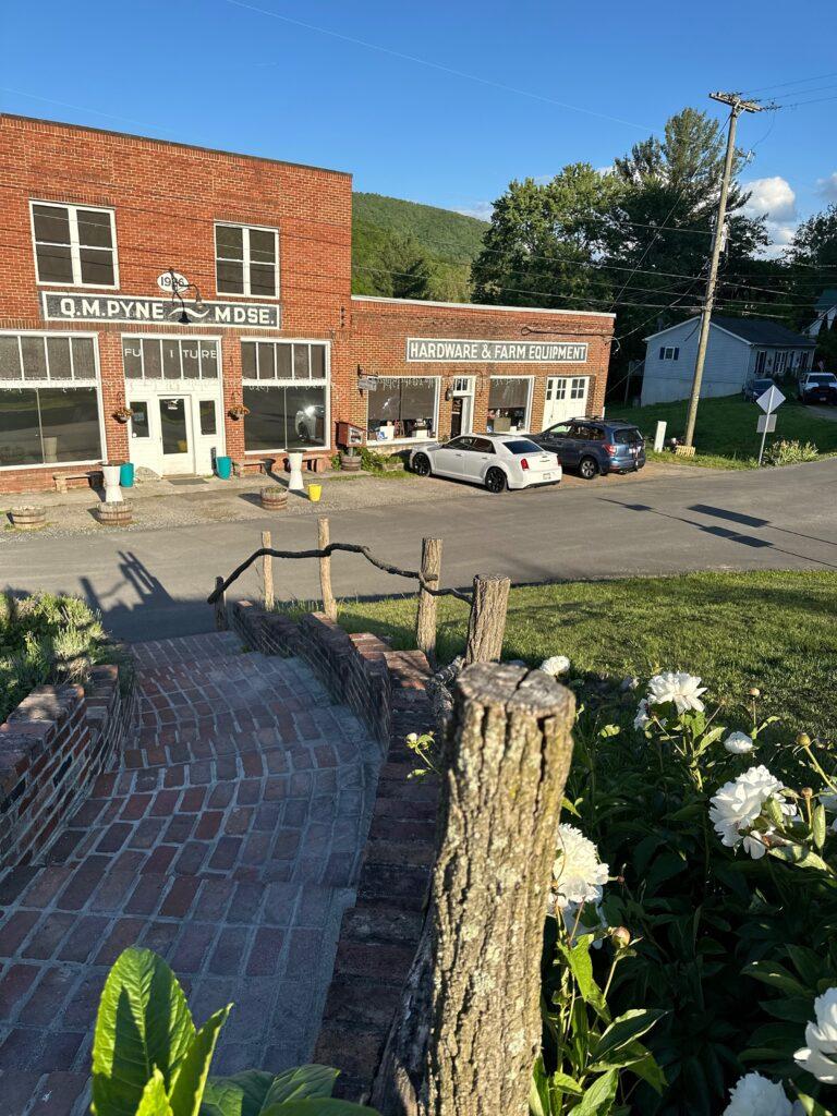 Exterior view of the Palisades Restaurant with stairs leading down to road at white front door